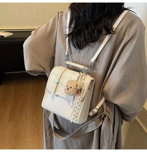 Detail of a plaid beige tote bag with a cute bear pendant and colorful tassel on the back