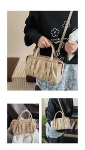Makro-Detailansicht der khakifarbenen PU-Handtasche mit Falten und Goldbeschlägen