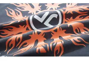 Detail of grey cotton fabric with orange flame print and white YC logo on long sleeve tee
