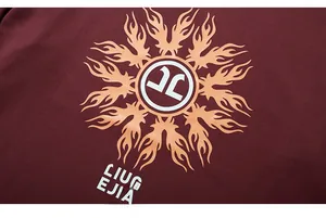 Detail of burgundy cotton T-shirt featuring high-quality flame art print and logo
