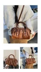 Detail der dunkelbraunen Boston-Tasche mit Falten aus weichem PU-Leder und Doppelgriffen