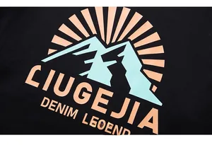 Detailansicht des bunten Bergdrucks und der fetten Schrift auf schwarzem Baumwollshirt