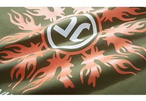 Macro shot of orange flame sun print and VC logo on dark green long sleeve shirt