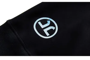 Close-up of black oversized sweatshirt sleeve showing dense knit fabric and round logo print