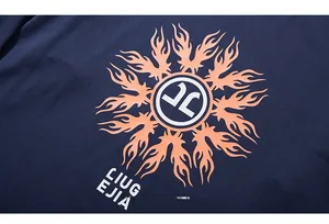 Detail of orange flame sun print and white LIUG EJIA text on navy blue knit t-shirt fabric