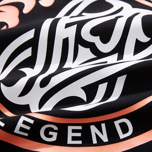 Close-up of black cotton T-shirt featuring white artistic print and orange Legend text