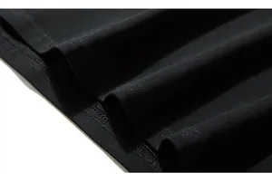 Detail shot of black knitted hem with professional stitching and fine fabric texture