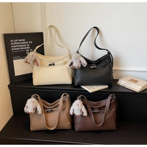 Litchi texture leather handbags in four colors featuring decorative metal buckles and plush charms