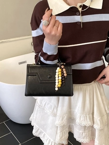 Minimalist black faux leather handbag with vintage beaded charm accent for casual wear