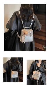 Detail of silver metallic backpack with check pattern flap and plush bear charm decoration