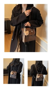 Detail of vintage brown convertible backpack with teddy bear charm and striped ribbon accent