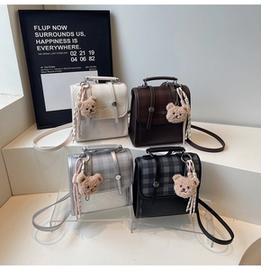 Detail view of mini plaid backpacks in four colors with cute bear charms and ribbons