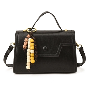 Vintage black crossbody bag with faux oil leather texture and beaded charm