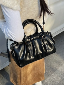 Elegant black pleated satchel with gold hardware and adjustable strap for daily use