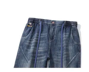 Detail of elastic drawstring waistband on blue vintage washed tapered joggers