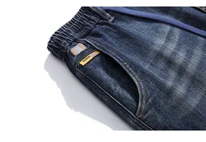 Close-up of elastic waistband with purple drawstring and vintage label on jeans