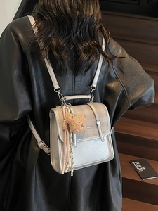 Vintage silver backpack with plaid flap and bear charm shown on model in real use