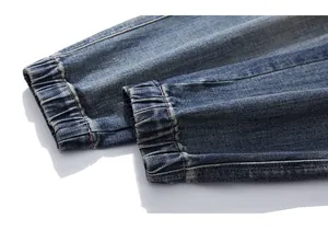 Detail of elastic jogger cuffs and neat stitching on washed blue denim jeans