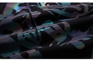 Dettaglio macro della stampa laser arcobaleno iridescente su t-shirt streetwear nera
