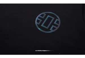 Dettaglio della t-shirt nera con testo LIUGEJIA riflettente e grafica circolare colorata