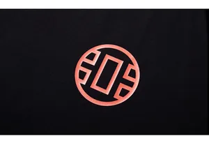 Close-up of the orange circular graphic print on high-quality black cotton fabric
