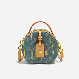 Dettaglio borsa rotonda in denim monogram con finiture in pelle marrone e oro lucido