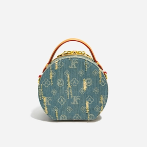 Dettagli della borsa tonda in denim con motivi jacquard, manici in pelle e hardware oro