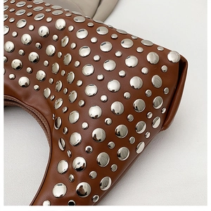 Gros plan détaillé du sac hobo en cuir marron avec des décorations de rivets argentés