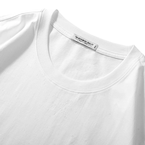 Close-up of white crew neck cotton T-shirt collar with EST.1981 woven label and 3XL tag