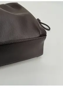 Détail du fond renforcé d'un sac en cuir marron avec grain fin et coutures robustes
