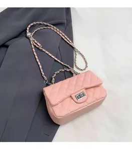 Detail of pink quilted pattern texture with metal turn-lock and leather chain strap
