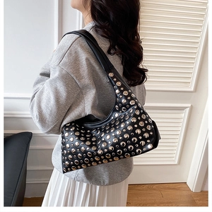 Détail du sac bandoulière en cuir noir avec rivets argentés punk sur les côtés