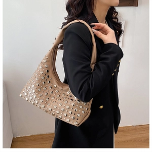 Dettaglio di una borsa Hobo beige a forma di luna con borchie argentate sulla modella