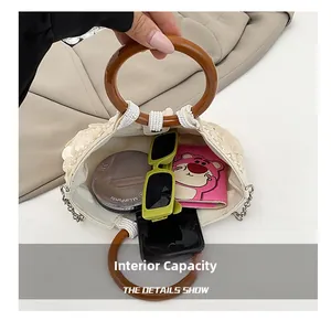 Detail showing the internal capacity of the white beaded handbag with accessories