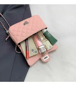 Detail view of pink quilted chain bag interior with silver clasp and ample storage space