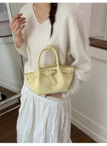 Détail du sac seau plissé jaune pâle avec texture en cuir crème et boucle en métal argenté