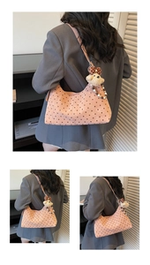 Dettaglio borsa hobo rosa a pois con ciondolo a forma di cane e perline a fiocco