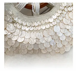 Close-up of handmade sequin bag with fish scale pattern and beaded circular handle