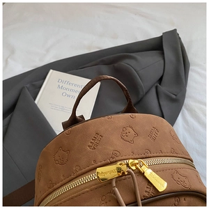 Detailaufnahme brauner Wildlederrucksack mit Katzenprägungen und goldenen Reißverschlüssen