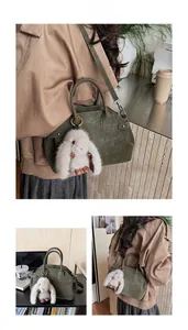 Detail of vintage green baguette bag with soft plush bunny charm and round handle