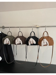 Detail view of four baguette bags in olive, brown, black, and tan with rabbit charms