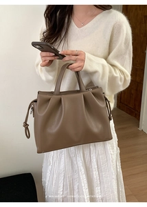 Détail du sac cabas plissé marron foncé avec nœuds de serrage et texture cuir