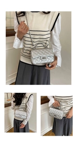Macro detail of silver quilted rhombic handbag with metal chain and turn-lock closure