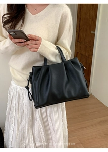 Détail du sac cabas plissé noir minimaliste avec cordons et texture cuir grainé