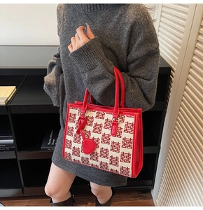 Dettaglio borsa da sposa rossa con motivo jacquard Doppia Felicità e ciondolo a cuore rosso