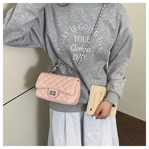 On-body view of a pink quilted chain crossbody bag with metallic turn-lock and leather strap