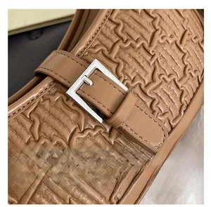 Close-up of brown textured leather loafer with silver rectangular buckle detail