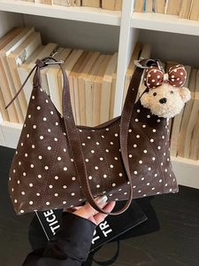 Borsa a spalla marrone scuro a pois con ciondolo a orsetto su scaffale retrò