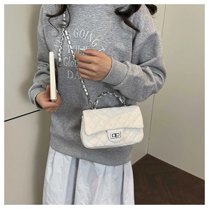 Detailed view of white quilted chain bag with silver twist lock and adjustable metal ball