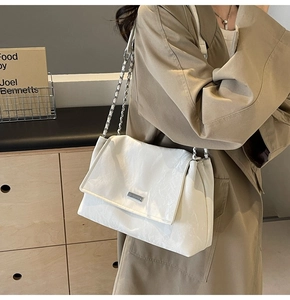 Dettaglio della borsa a tracolla bianca in pelle marmorizzata con fibbia d'argento